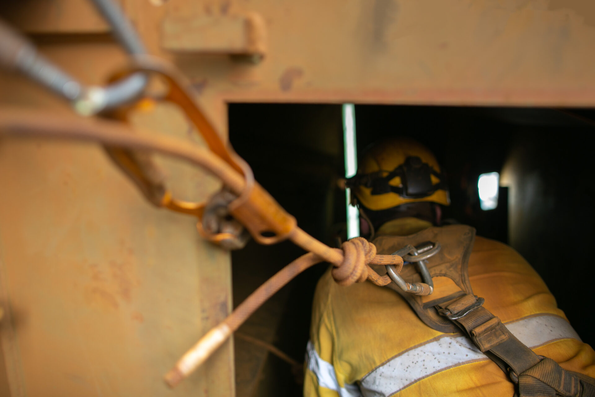 Close up shot of rope access worker wearing safety harness, helmet