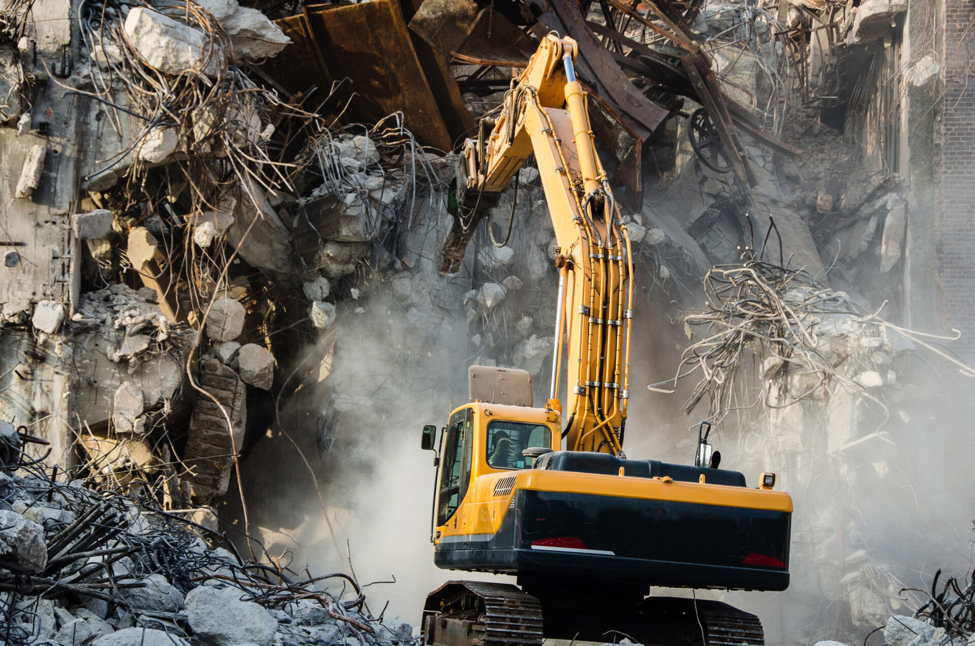 Excavator working at the demolition of an old industrial building