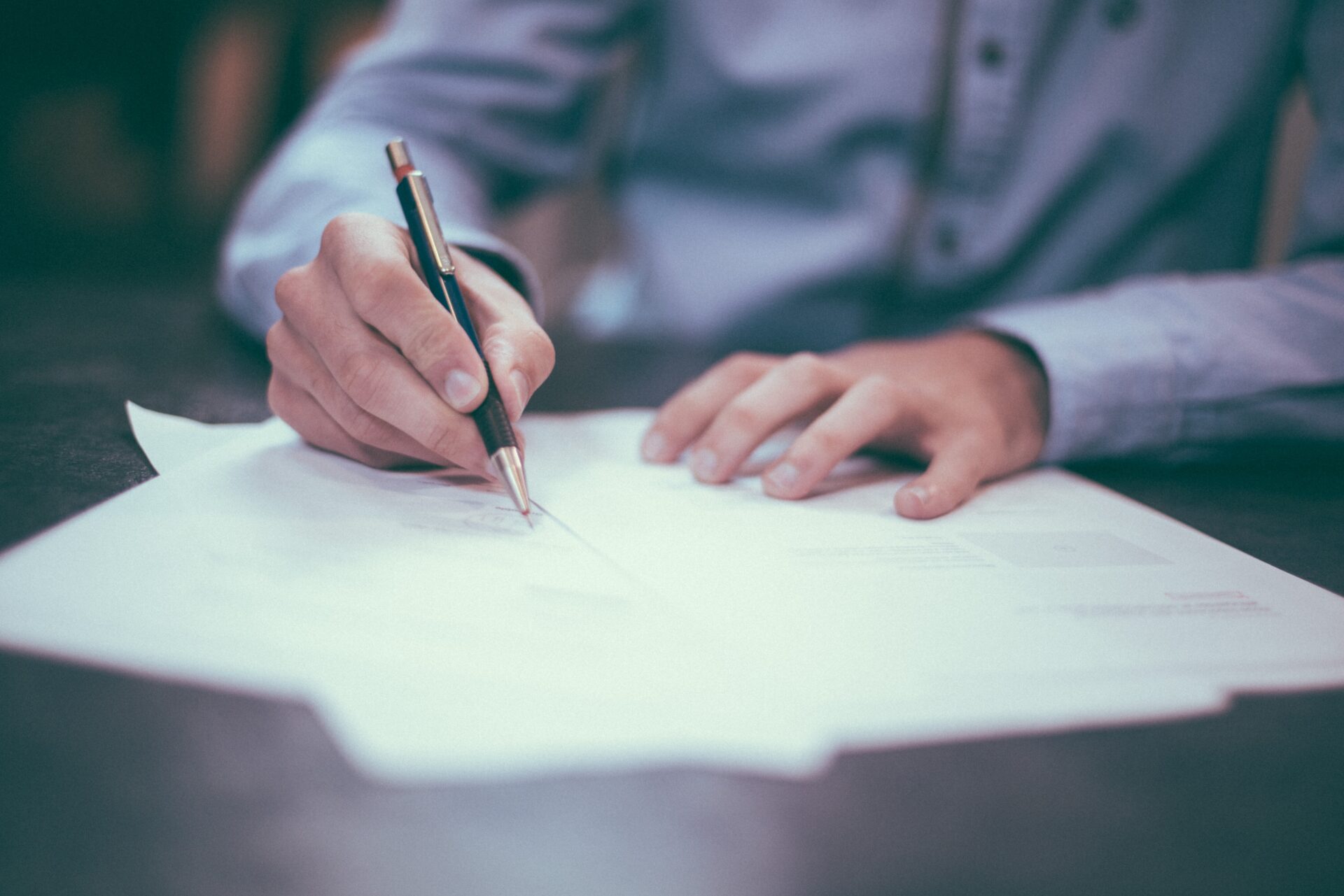 man singing a contract sitting at a table