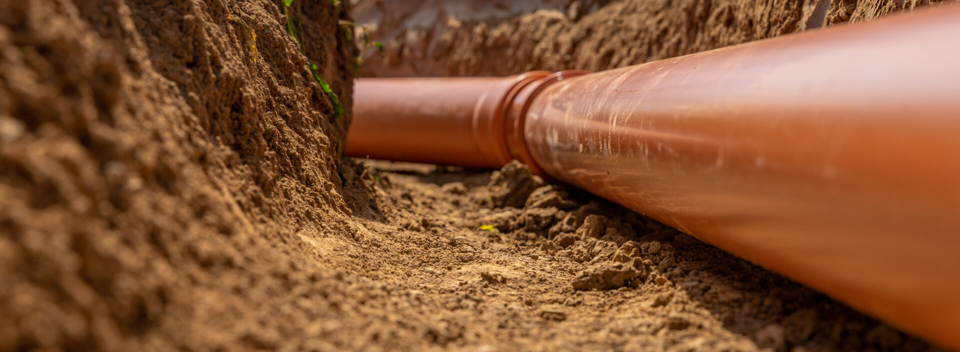 Plastic pipes in the ground during the construction of a building, bunner with copy space